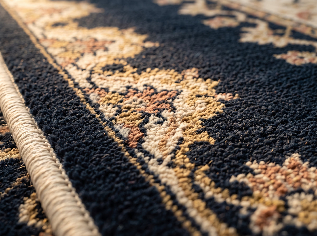 A close view of the rug's pile and bound edge, showing the woven construction.