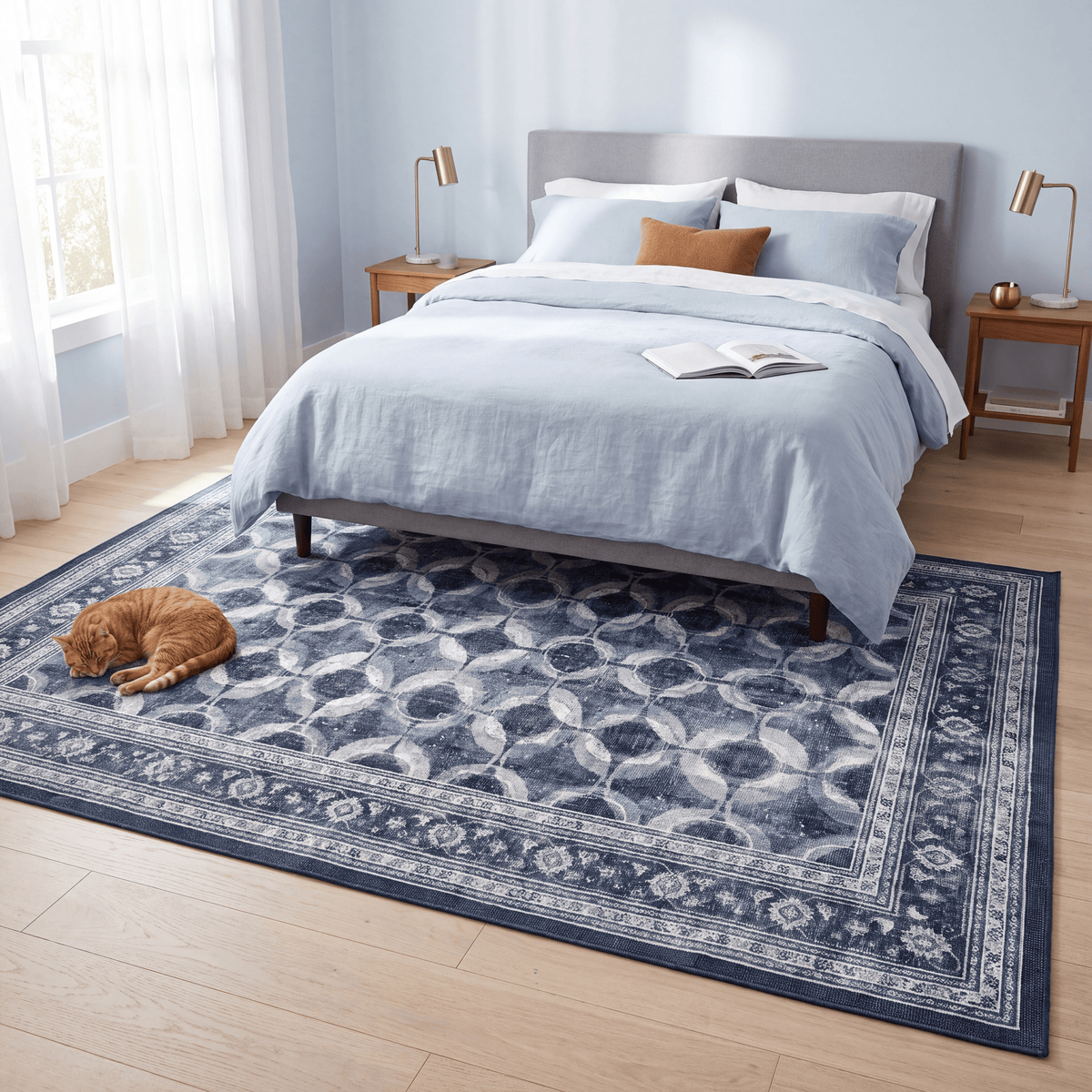 The rug at the foot of a bed with a cat asleep on it.