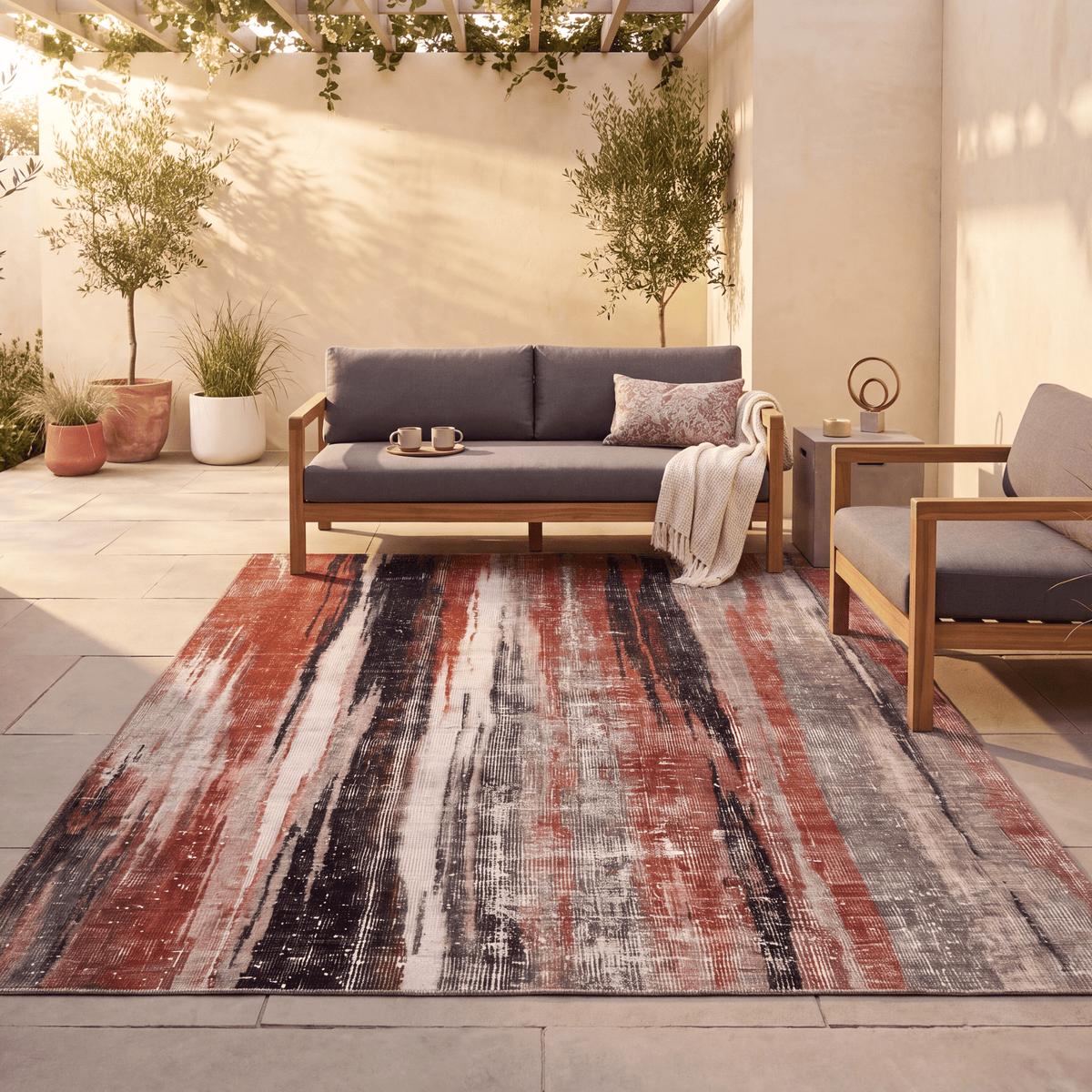 The rug laid flat on a patio beside outdoor seating.