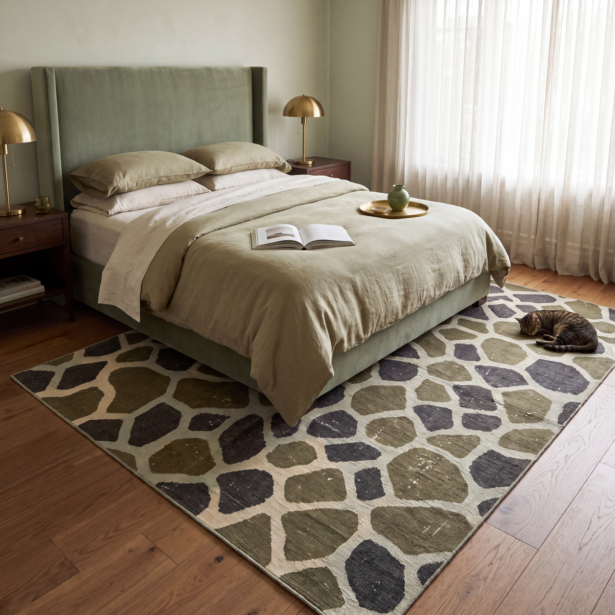 The rug at the foot of a bed with a cat asleep on it.