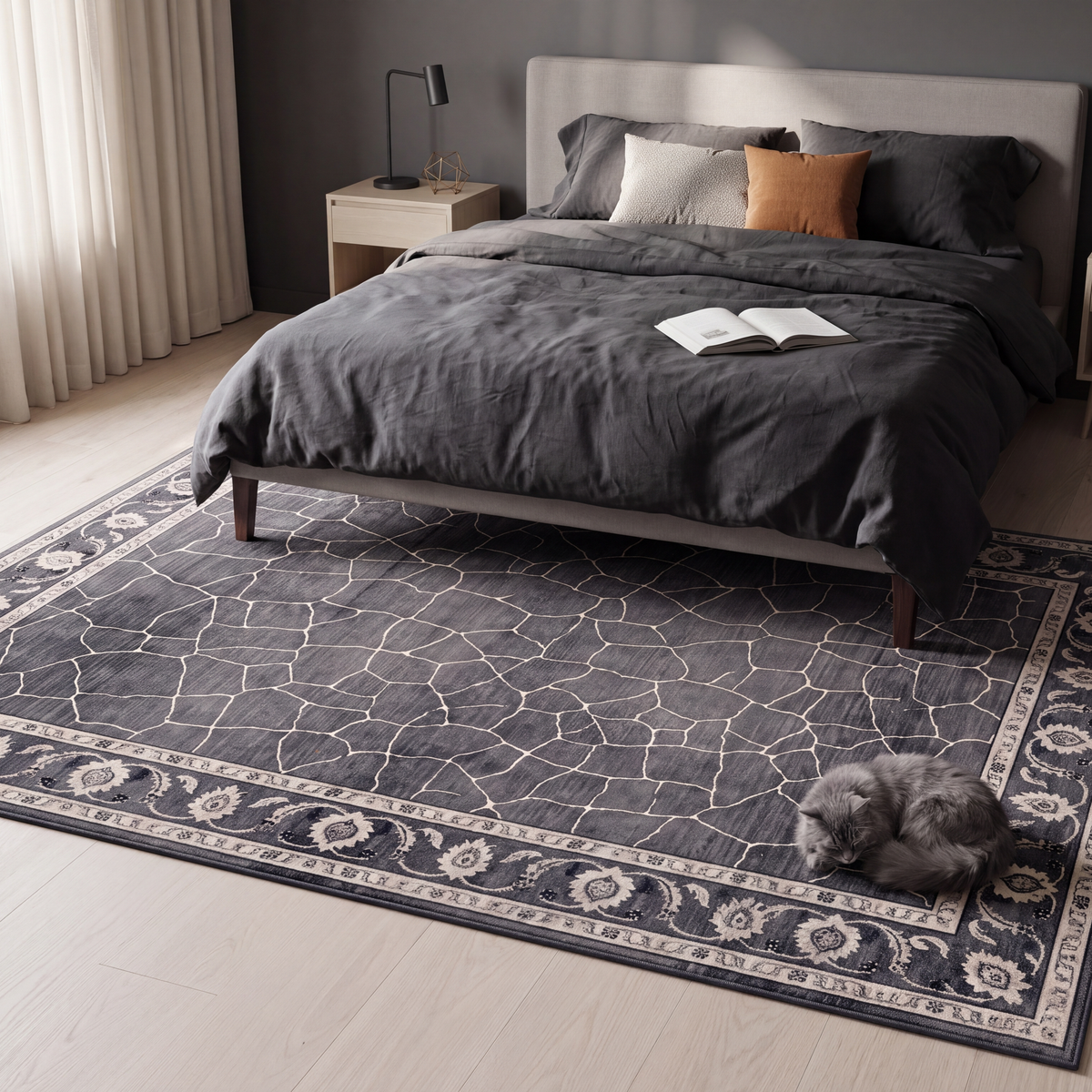 The rug at the foot of a bed with a cat asleep on it.