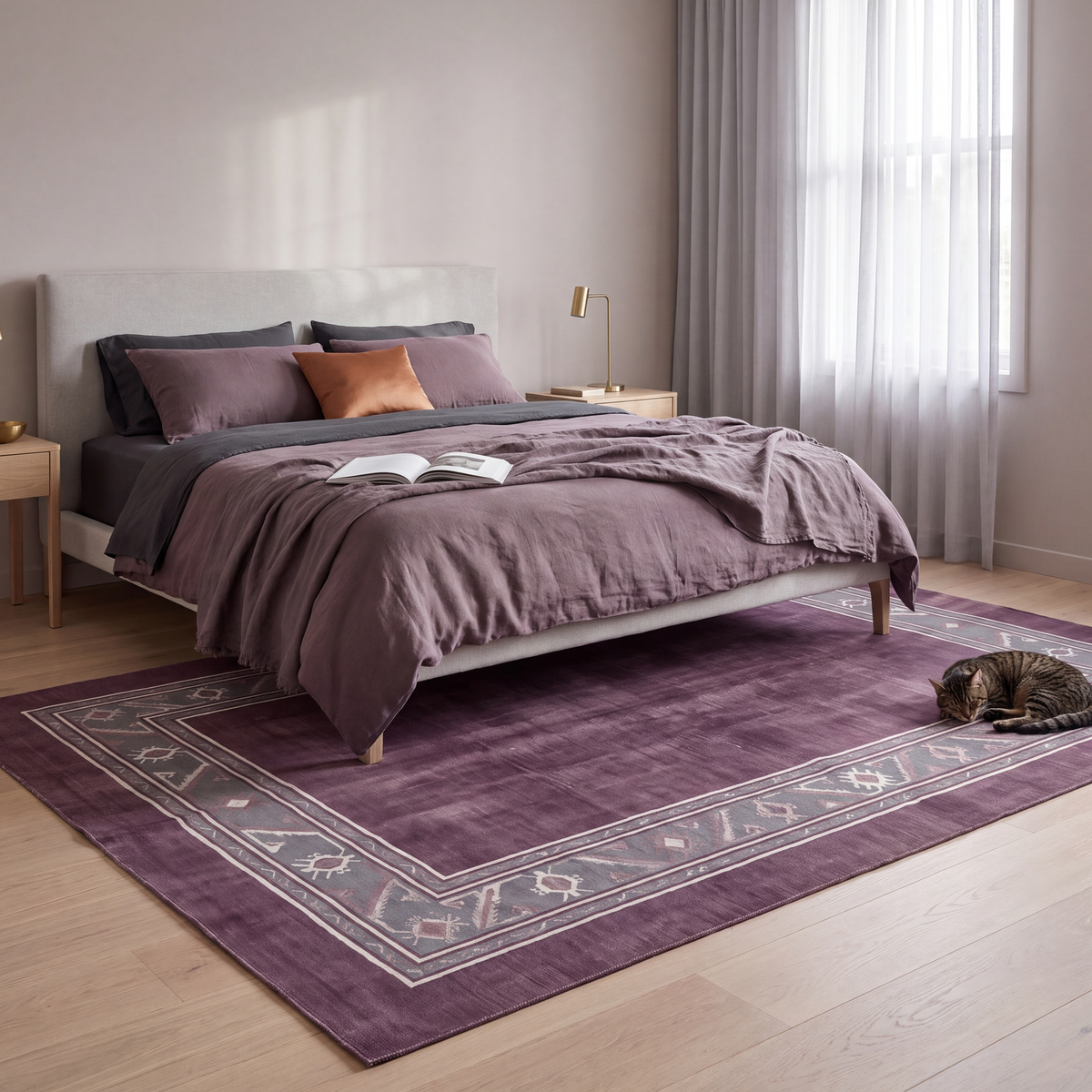 The rug at the foot of a bed with a cat asleep on it.