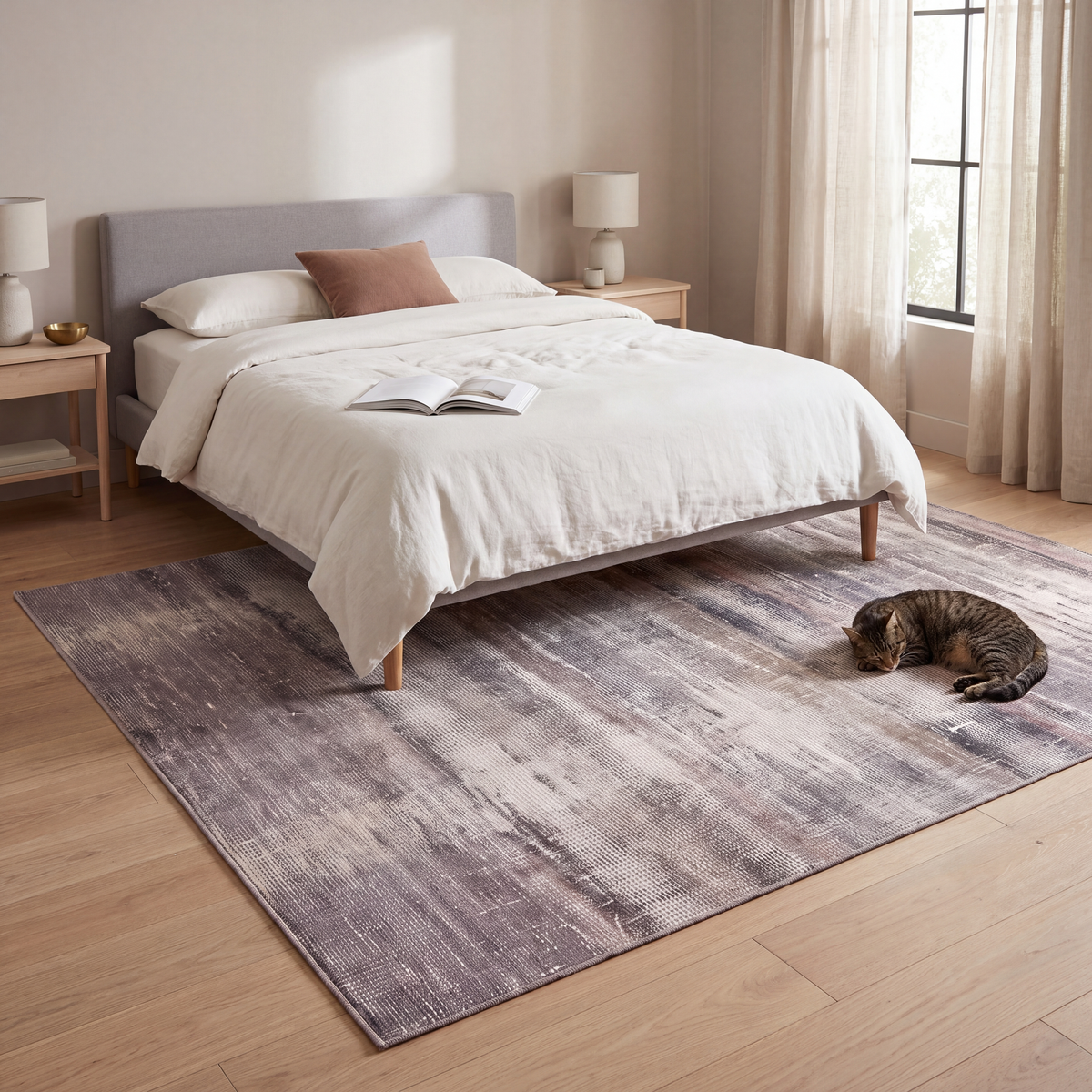 The rug at the foot of a bed with a cat asleep on it.