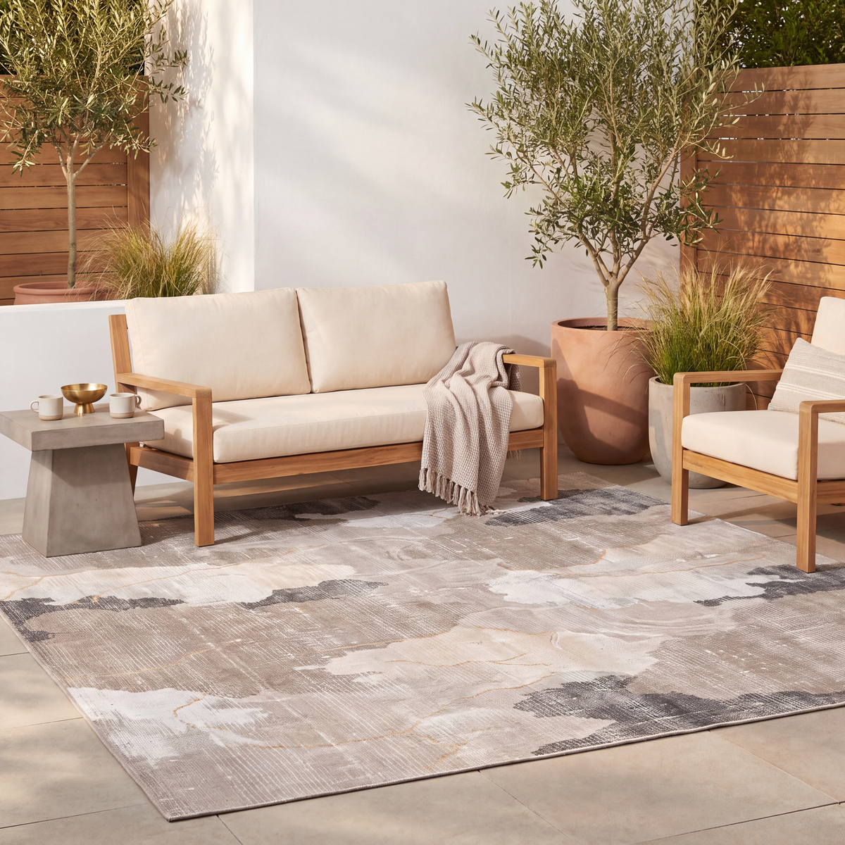 The rug laid flat on a patio beside outdoor seating.