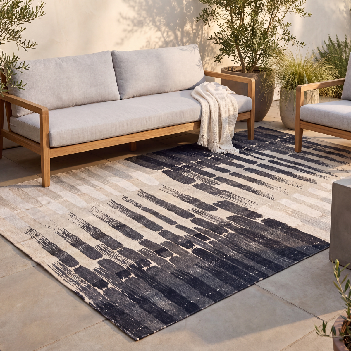 The rug laid flat on a patio beside outdoor seating.